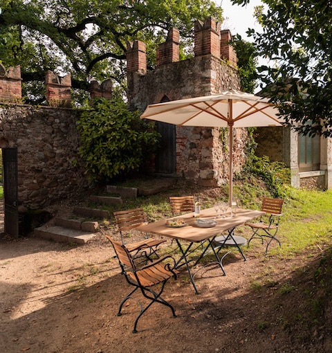 Tisch-Kombo Classic und Sonnenschirm von Weishäupl vor Gartenmauer – erhältlich bei Seeckts