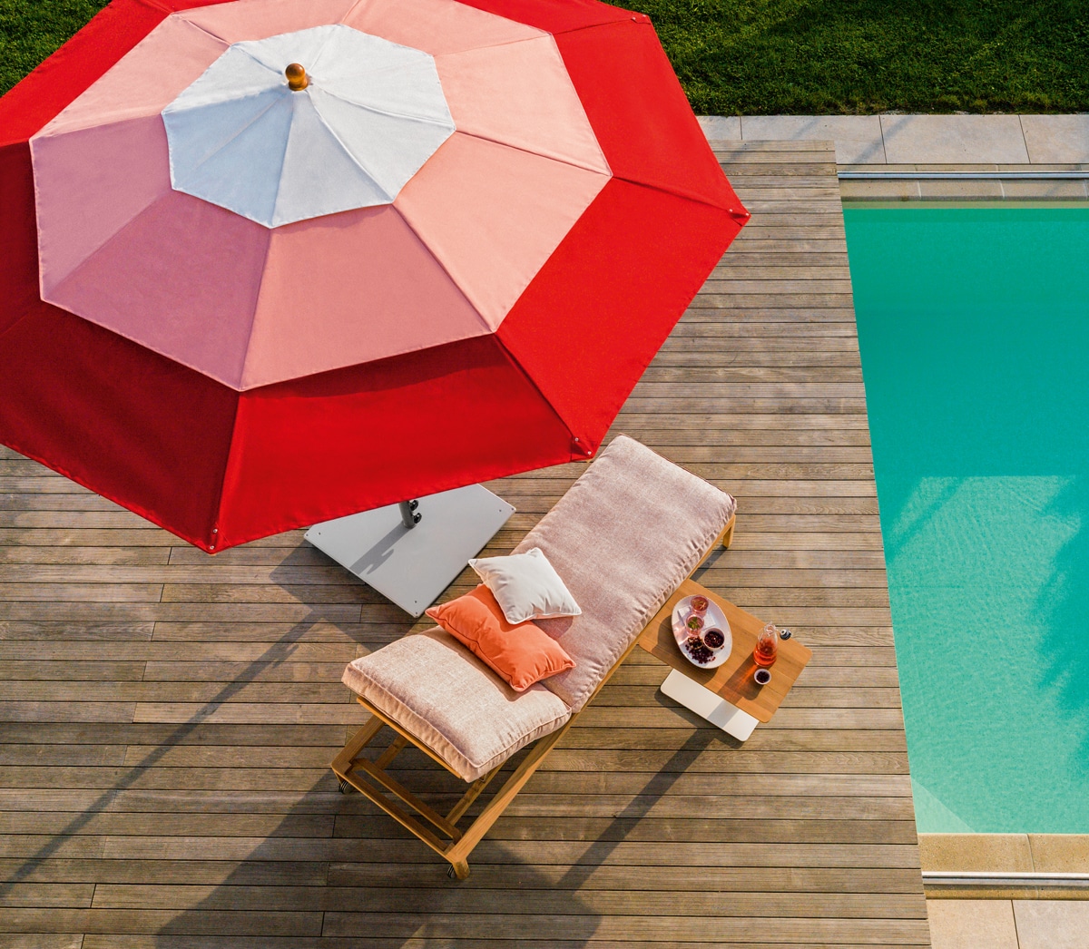 Vogelperspektive auf Liegestuhl mit Sonnenschirm neben Pool