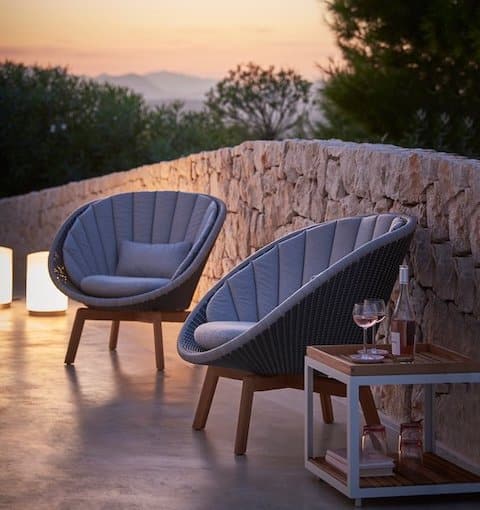 Loungestühle auf Terrasse bei Sonnenuntergang